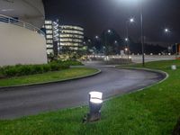 some street lights that are sitting in the grass by the road curb of the city