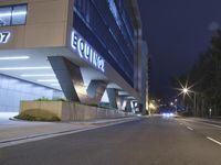 an illuminated building in the city at night and a street that has a median median