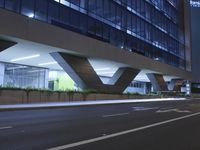 an illuminated building in the city at night and a street that has a median median