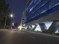 an illuminated building in the city at night and a street that has a median median