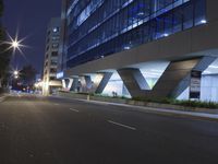 an illuminated building in the city at night and a street that has a median median