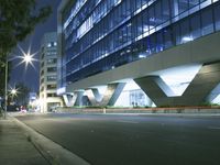 an illuminated building in the city at night and a street that has a median median