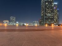 a very long view of some lights and buildings at night in the city with a skate board