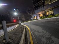 the view from an intersection in the city at night of a traffic light, with a car going by