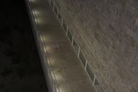 some concrete steps near a building at night with a blue sky in the background and a street lamp