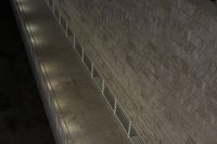 some concrete steps near a building at night with a blue sky in the background and a street lamp