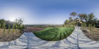 the circular fish eye lens is shown as a view of a city park and field