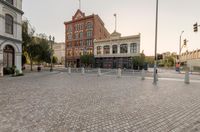 a stone city square is shown in a wide format, with lights and buildings behind it