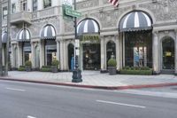 the street has several arched windows and a store front with awnings on it