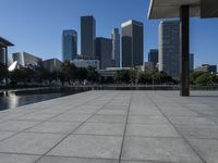 the city is in the background with other buildings in it by water with people walking on it