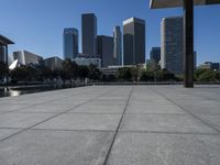 the city is in the background with other buildings in it by water with people walking on it