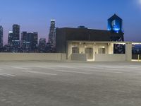 the night sky is reflecting off the concrete building with the city skyline in the background