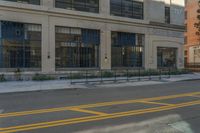 a red fire hydrant is sitting on the curb of a city street in front of a tall building