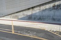 the city street is lined with buildings and empty spaces in the background, with a concrete wall on the far side of the road