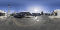 a fish eye view of a car on the street, with buildings and cars in the background