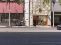 the woman is riding her bike along the side of the road, looking into the storefront