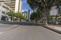 a city street with buildings and cars driving by it, with the words stop right by and a blurry image of trees behind the car