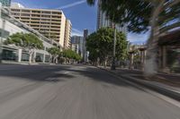 a city street with buildings and cars driving by it, with the words stop right by and a blurry image of trees behind the car