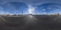 a view from a fish eye lens shows a city street and sky in the background