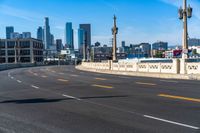a motorcycle rides down a highway through a city with tall buildings in the distance on a clear day