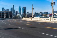 a motorcycle rides down a highway through a city with tall buildings in the distance on a clear day