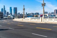 a motorcycle rides down a highway through a city with tall buildings in the distance on a clear day