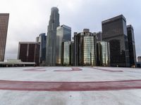 a city has some big high rise buildings in the background while an empty parking lot lies beneath