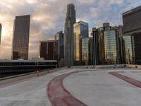 there are many buildings in this city and the ground is concrete and cement at sunset