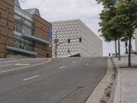 an empty street is shown in front of the museum's building and sidewalk with an empty bench