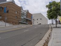 an empty street is shown in front of the museum's building and sidewalk with an empty bench