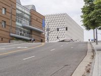 an empty street is shown in front of the museum's building and sidewalk with an empty bench