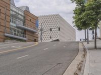 an empty street is shown in front of the museum's building and sidewalk with an empty bench