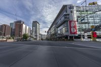 cars and buses travel down an empty city street near tall buildings in downtown, calgary