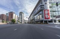 cars and buses travel down an empty city street near tall buildings in downtown, calgary