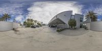 an 360 - view picture of a modern building in arizona, united states, with palm trees and cars parked outside