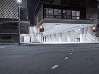 an empty street is lit with traffic lights, in the middle of the night,