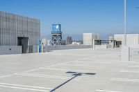 a parking lot with a water tower in the background near a city skyline, and buildings