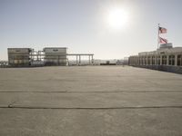 an airport that has buildings and airplanes in the background, as seen from a rooftop