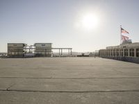 an airport that has buildings and airplanes in the background, as seen from a rooftop