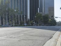 a person walking down a deserted city street with skyscrapers in the background in the daytime