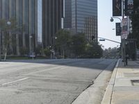 a person walking down a deserted city street with skyscrapers in the background in the daytime