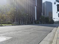 a person walking down a deserted city street with skyscrapers in the background in the daytime