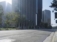 a person walking down a deserted city street with skyscrapers in the background in the daytime