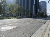 a person walking down a deserted city street with skyscrapers in the background in the daytime