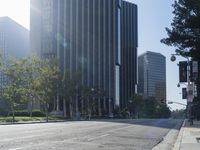 a person walking down a deserted city street with skyscrapers in the background in the daytime