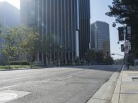 a person walking down a deserted city street with skyscrapers in the background in the daytime