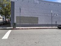 a building with a mural on it's side painted blue next to a curb