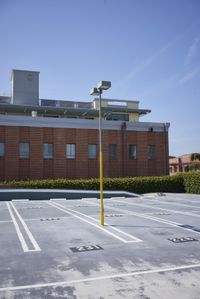 an empty parking lot with an overhead sky view behind it and a small building near by