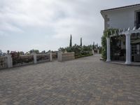 a large brick patio is adjacent to a private residence with a garden and fountain area