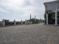 a large brick patio is adjacent to a private residence with a garden and fountain area